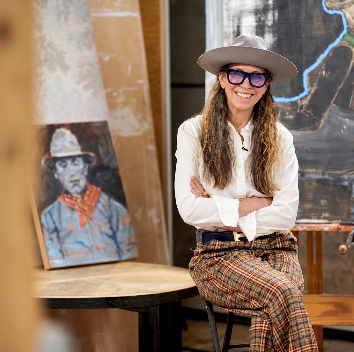 Annie Decamp seated in her studio surrounded by paintings